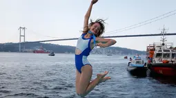 Seorang Atlet renang wanita bergembira setelah mengikuti lomba renang dari Asia hingga Eropa di Selat Bosphorus ke-30, Istanbul, Turki, (22/7). (AP Photo/Lefteris Pitarakis)