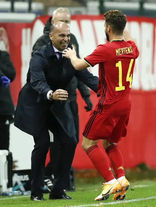 Penyerang Belgia, Dries Mertens berselebrasi dengan pelatihnya Roberto Martinez  usai mencetak gol ke gawang Inggris pada pertandingan UEFA Nations League di stadion King Power di Leuven, Belgia, Minggu (15/11/2020). Belgia menang atas Inggris 2-0. (AP Photo/Francisco Seco)
