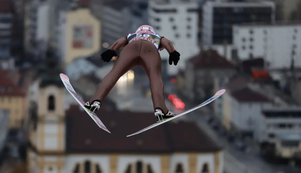 Atlet ski Polandia, Dawid Kubacki meluncur di udara pada putaran percobaan turnamen Four Hills Ski Jumping ke-65 di Innsbruck, Austria, Rabu (3/1). Turnamen ski bergengsi itu akan berakhir di Bischofshofen pada 6 Januari2018. (AP/Matthias Schrader)