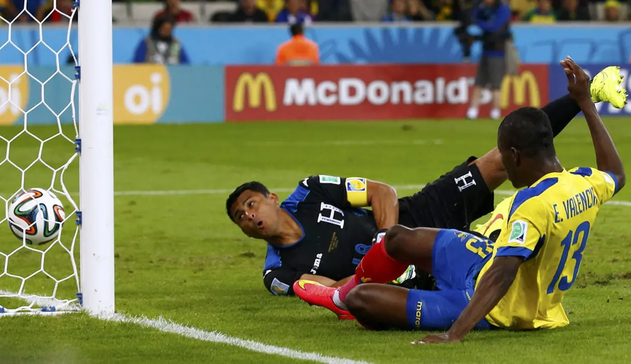 Gelandang Ekuador, Enner Valencia (kanan), berhasil mengecoh dan menjebol gawang Honduras yang dikawal Noel Valladares di laga kedua penyisihan Piala Dunia 2014 di Stadion Baixada, Curitiba, Brasil, (21/6/2014). (REUTERS/Darren Staples)