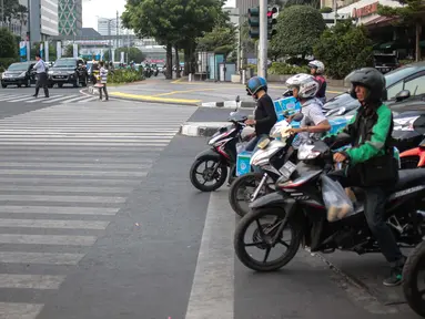Pengendara sepeda motor melanggar garis berhenti lampu merah Jalan MH Thamrin, Jakarta, Kamis (4/10). Masih banyak pengendara yang melanggar dan tidak mengindahkan penerapan tilang elektronik. (Liputan6.com/Faizal Fanani)