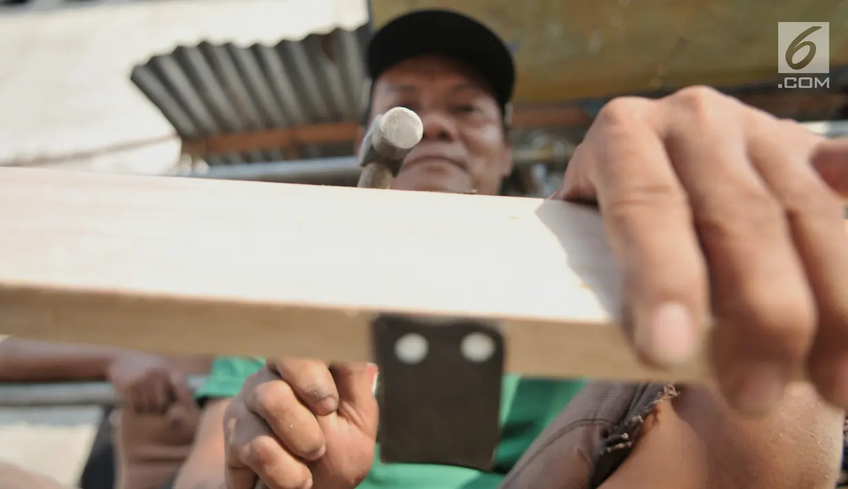 Perajin memproduksi permainan tradisional bakiak di Jakarta, Kamis (1/8/2019). Memasuki bulan Kemerdekaan, produksi bakiak rumahan milik Bang Bandit ini mampu menghasilkan 150 pasang per hari dengan harga jual Rp 25 ribu-35 ribu dan telah dipasarkan hingga ke Bekasi. (merdeka.com/Iqbal S Nugroho)