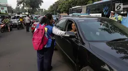 Petugas Dinas Perhubungan membagikan selebaran sosialisasi pemberlakuan sistem ganjil genap di pintu masuk Gardu Tol Cibubur 2, Jakarta, Senin (16/4). Aturan ini diujicobakan di Gerbang Tol pada  Senin 16 April 2018. (Liputan6.com/Faizal Fanani)