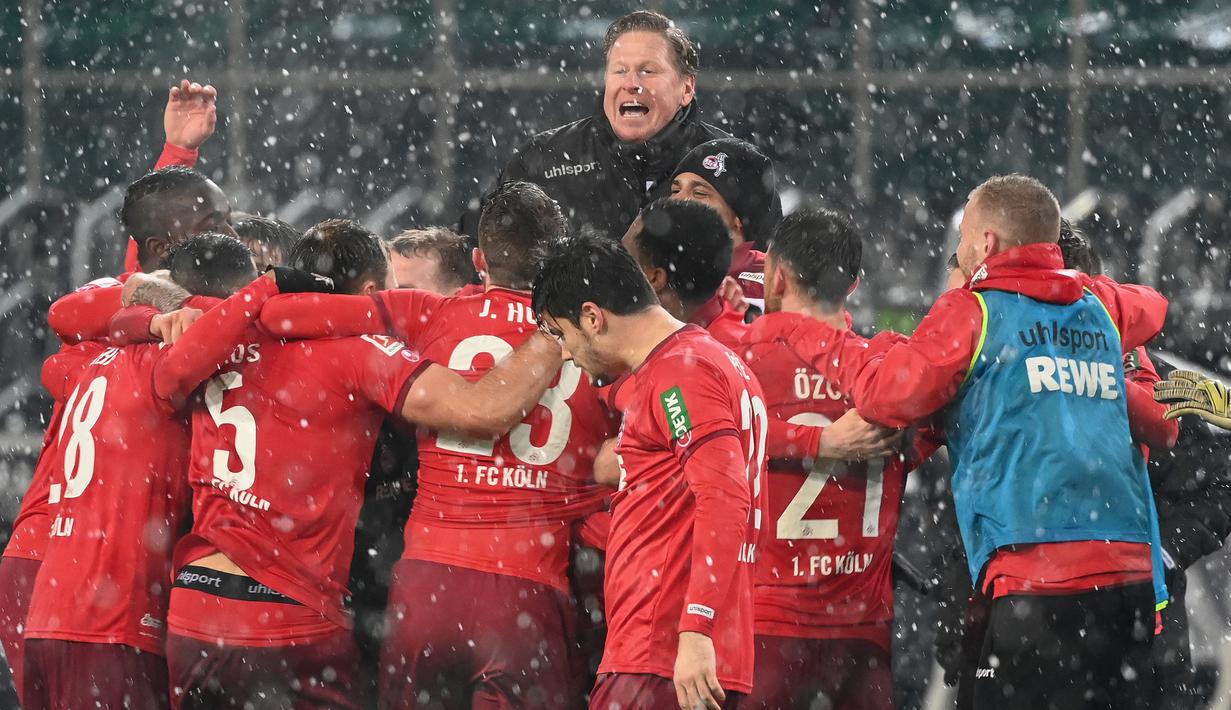 Manajer tim FC Koln, Markus Gisdol (tengah) dan para pemainnya melakukan selebrasi usai mengalahkan Borussia Moenchengladbach 2-1 dalam laga lanjutan Liga Jerman 2020/21 pekan ke-20 di Borussia Park, Sabtu (6/2/2021). (AFP/Ina Fassbender/Pool)