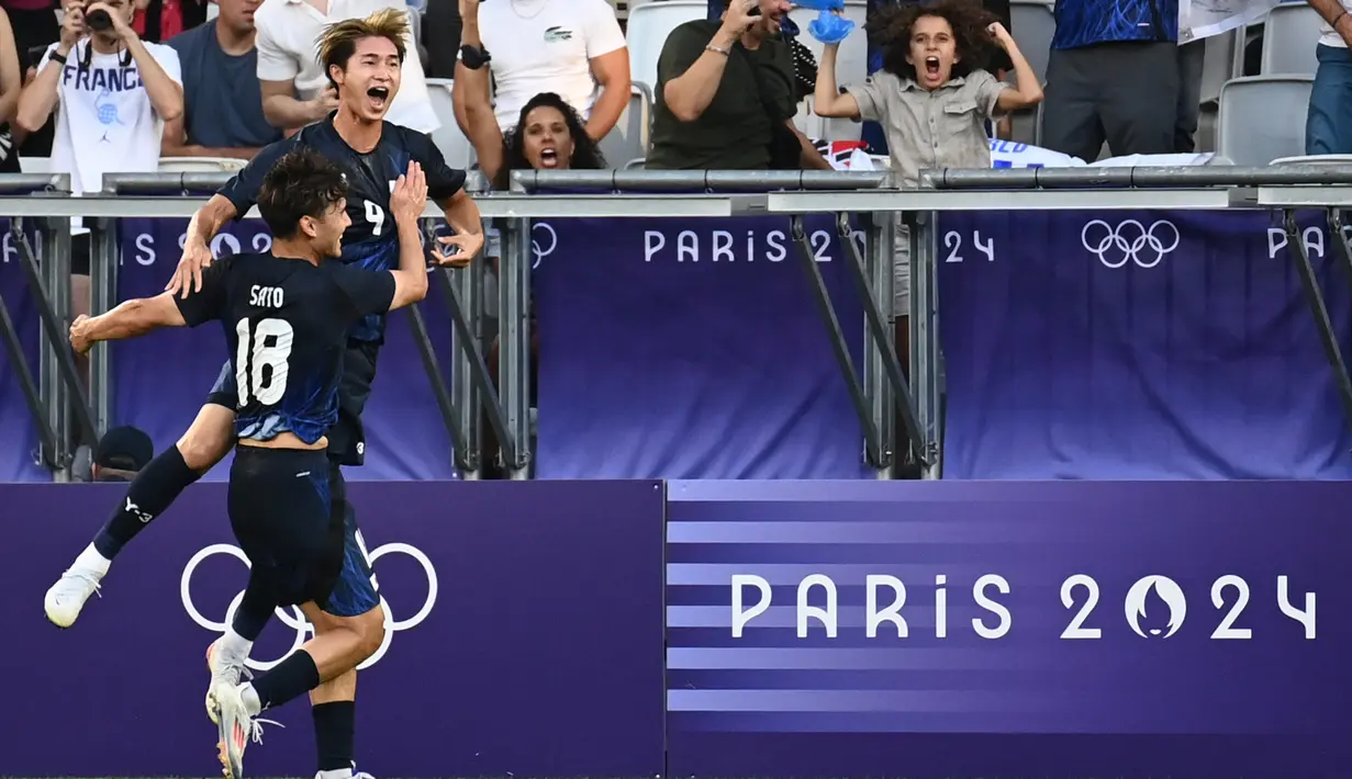 Penyerang Jepang #09 Shota Fujio (Atas) merayakan bersama Kein Sato setelah mencetak gol keempat timnya ke gawang Paraguay pada laga Grup D Olimpiade 2024 di Stade Matmut-Atlantique, Bordeaux, Kamis (25/7/2024) dini hari WIB. (Christophe ARCHAMBAULT / AFP)