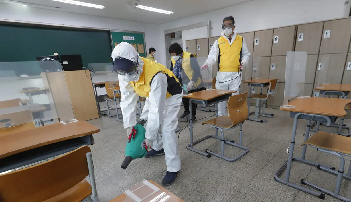Petugas kesehatan mendisinfeksi ruang kelas untuk ujian masuk perguruan tinggi di Seoul, Korea Selatan, Selasa (1/12/2020). Sekitar 490.000 siswa lulusan sekolah menengah atas di Korea Selatan akan menjalani Tes Kemampuan Skolastik Perguruan Tinggi pada 3 Desember 2020. (AP Photo/Ahn Young-joon)