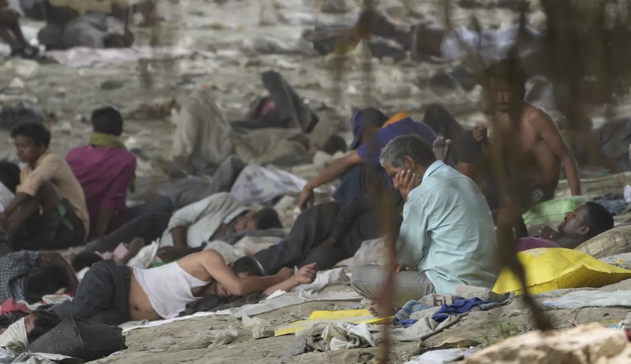 Para tunawisma tidur di bawah naungan jembatan layang pada hari yang panas di New Delhi, Jumat (20/5/2022). Ibu kota India dan sekitarnya tengah menghadapi kondisi gelombang panas yang ekstrem. (AP Photo/Manish Swarup)