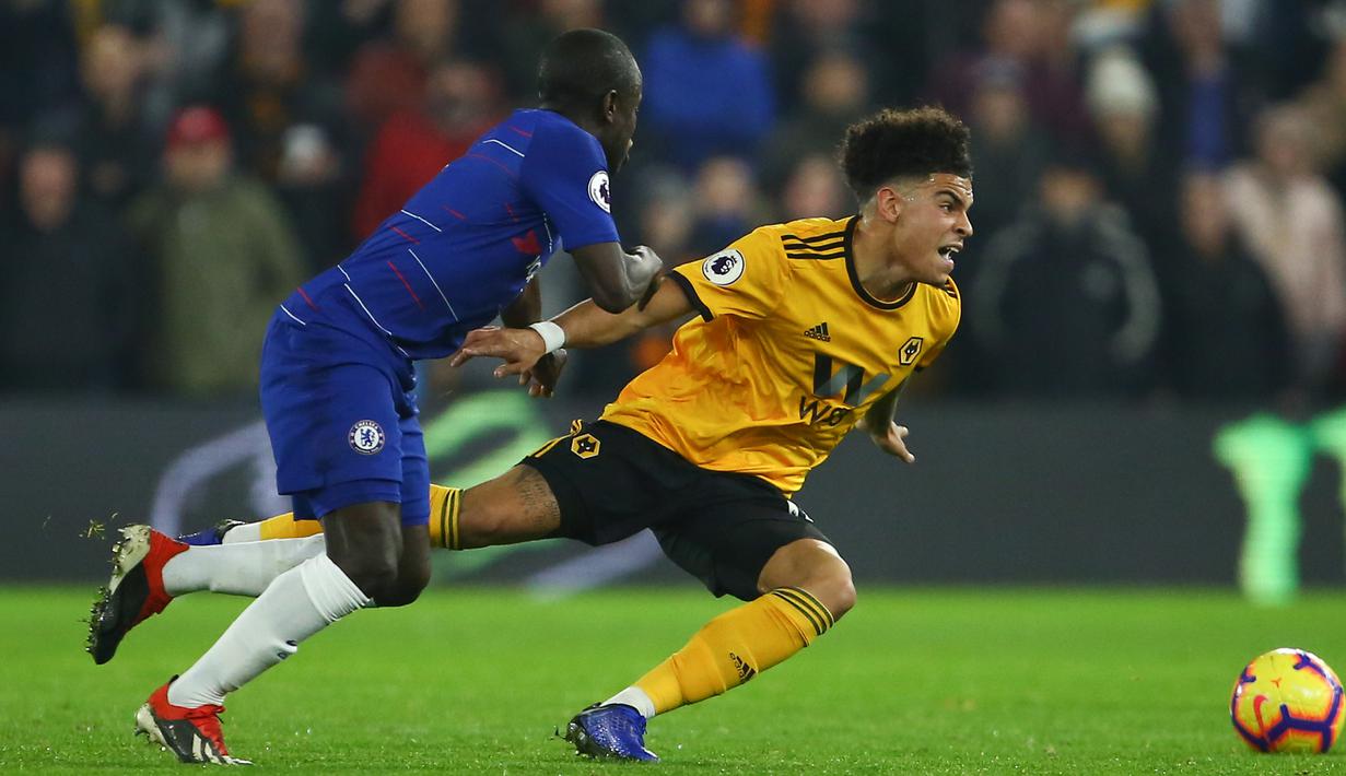 Gelandang Chelsea, N'Golo Kante, berebut bola dengan gelandang Wolverhampton, Morgan Gibbs-White pada laga Premier League di Stadion Molineux Wolves, Kamis (5/12). Wolves menang 2-1 atas Chelsea. (AFP/Geoff Caddick)