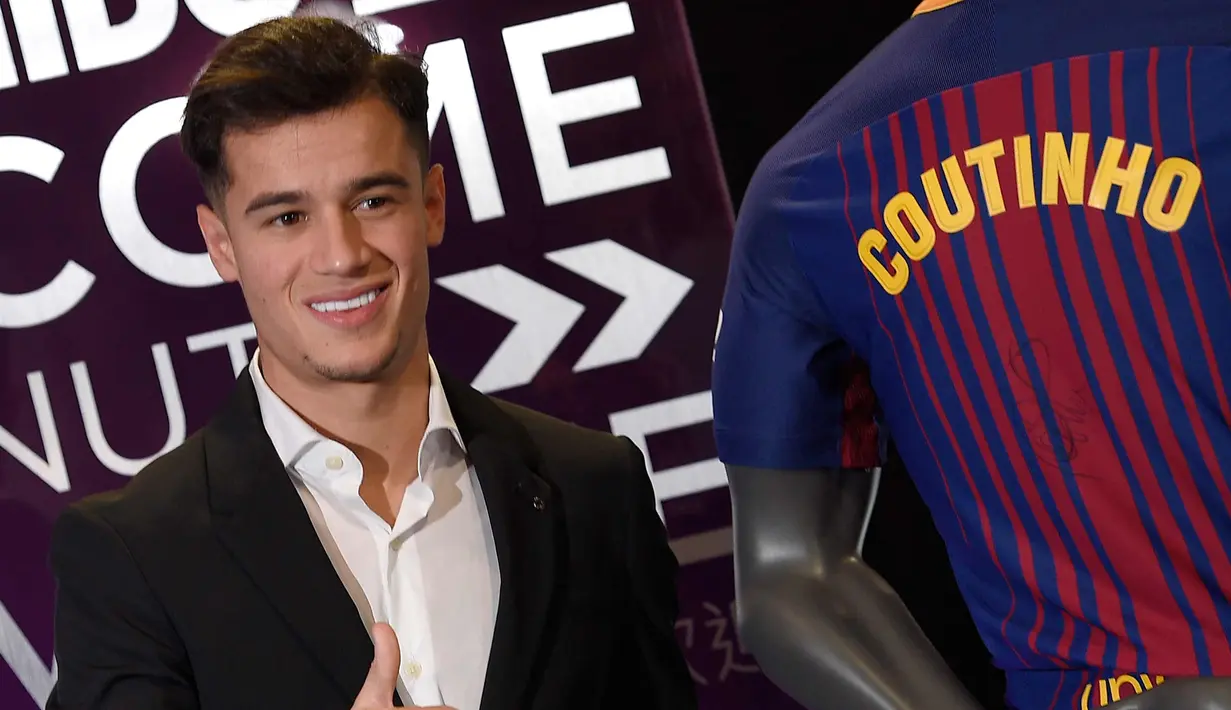 Gelandang Philippe Coutinho berpose dengan kostum tim barunya saat perkenalan dirinya di Barcelona (8/1). Coutinho diboyong Barcelona dengan harga sebesar 400 juta euro (sekitar Rp 6,45 triliun). (AFP Photo/Lluis Gene)