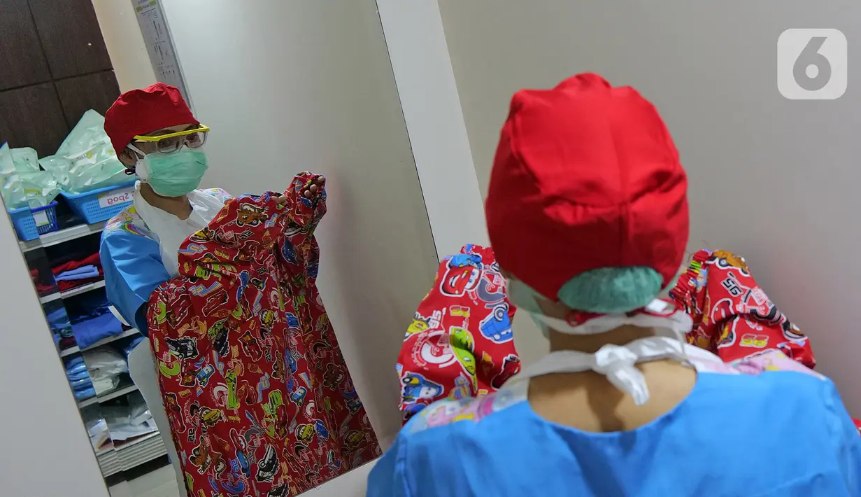 dr. J. Mila Hardiani C memakai Gown di ruang ganti anak  di RSIA Tambak, Jakarta, Kamis (18/6/2020). Dokter menggunakan APD lengkap tingkat II bertema khusus tersebut saat memeriksa pasien anak. (Liputan6.com/Herman Zakharia)