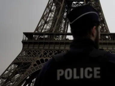 Seorang polisi Prancis berpatroli di dekat Menara Eiffel, di Paris, Kamis, 7 Desember 2023. (AP Photo/Thibault Camus)