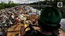 Petugas PPSU menggunakan alat berat mengumpulkan sampah sisa banjir di sepanjang Kali Cengkareng, Jakarta Barat, Kamis (9/1/2020). Sampah sisa banjir tersebut selanjutnya akan dibawa menggunakan truk pengangkut ke TPA Bantar Gebang. (Liputan6.com/Johan Tallo)