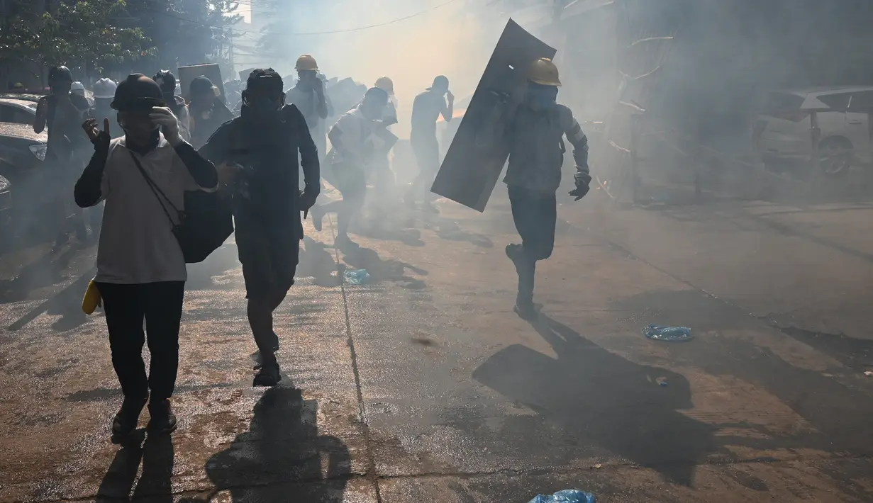 Para pengunjuk rasa lari setelah gas air mata ditembakkan selama demonstrasi menentang kudeta militer di Yangon (9/3/2021). Bentrokan warga anti kudeta militer dengan aparat keamanan Myanmar masih terus berlangsung. (AFP/STR)