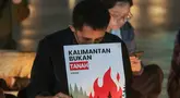 Sejumlah poster yang dibawa simpatisan masyarakat turut mewarnai aksi solidaritas dan doa bersama untuk korban kebakaran hutan dan lahan (karhutla) di Tugu Proklamasi, Jakarta, Senin malam (19/10/2026). (KLY/Budy Santoso)