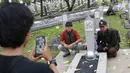 Warga saat foto di Taman Makam Pahlawan Kalibata di Jakarta, Kamis (9/11). Pembersihan tersebut dilakukan guna menyambut Hari Pahlawan yang diperingati setiap 10 November. (Liputan6.com/Immanuel Antonius)