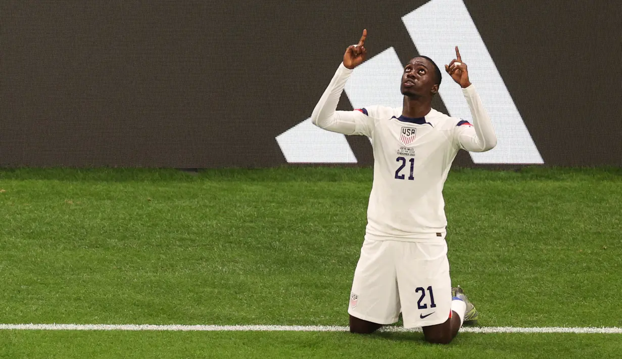 <p>Penyerang Timnas Amerika Serikat Timothy Weah melakukan selebrasi setelah mencetak gol pertama timnya pada pertandingan sepak bola Grup B Piala Dunia Qatar 2022 antara Amerika Serikat dan Wales di Stadion Ahmad Bin Ali di Al-Rayyan, Doha, Qatar, Senin (21/11/2022). Pemain bola kelahiran Amerika Serikat ini lebih memilih memperkuat timnas tanah kelahirannya dan menolak berada di sayap Liberia. (ADRIAN DENNIS/AFP)</p>