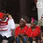 Presiden Joko Widodo atau Jokowi mendapatkan hadiah dari perwakilan anak-anak sekolah dasar Papua di Istana Merdeka, Jakarta, Jumat (11/10/2019). Pertemuan Jokowi dengan perwakilan anak-anak SD dari Papua digelar dalam suasana santai di beranda belakang Istana Merdeka. (Liputan6.com/Angga Yuniar)