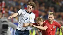 Pemain Austria, Martin Hinteregger (kanan) berebut bola dengan pemain Rusia, Mario Fernandes pada laga uji coba di Tivoli Stadium, Innsbruck, Austria, (30/5/2018). Austria menang atas Rusia 1-0. (AP/Kerstin Joensson)