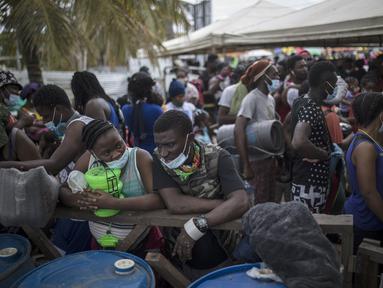 Para migran Haiti berkumpul sebelum menaiki perahu menuju Capurgana dekat perbatasan dengan Panama, di Necocli, Kolombia, Rabu (28/7/2021). Ribuan migran telah berkumpul di Necocli saat mereka bergerak ke utara menuju Panama dalam perjalanan mereka ke perbatasan AS. (AP Photo/Ivan Valencia)