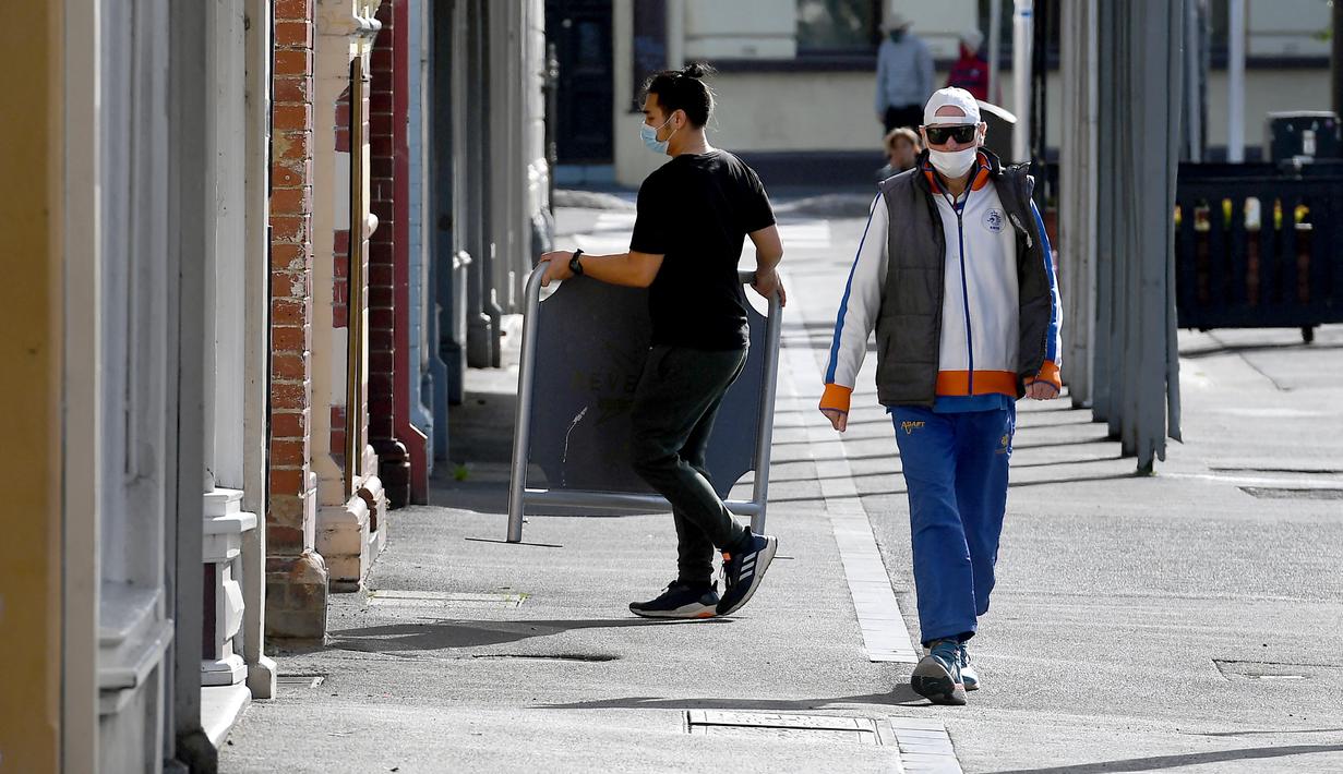 Seorang pekerja kafe melakukan aktivitas di jalan yang tenang saat kota itu mengalami penguncian keenam saat memerangi wabah varian Delta dari coronavirus.di Melbourne (25/8/2021). (AFP/William West)