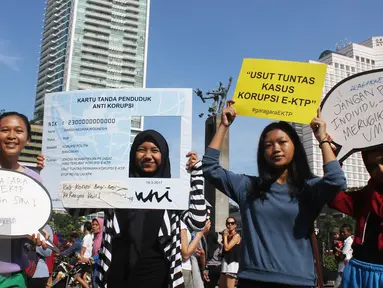 Perwakilan dari LSM, LBH dan aktivis yang tergabung Gerakan Sapu Koruptor (Satu Padu Lawan Koruptor) melakukan aksi simbolik kawal kasus korupsi E-KTP saat CFD di Kawasan Bundaran HI, Jakarta, Minggu (19/3). (Liputan6.com/Angga Yuniar) 