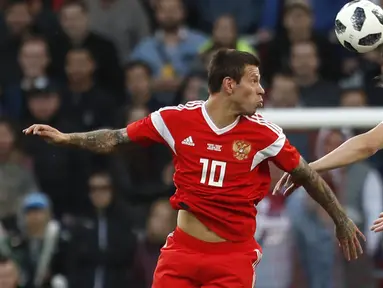 Duel pemain Russia, Fyodor Smolov (kiri) dan pemain Turki, Caglar Soyuncu pada laga uji coba di VEB Arena stadium, Moskow, Rusia, (5/6/2018). Rusia bermain imbang 1-1. (AP/Pavel Golovkin)