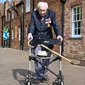 Veteran Perang Dunia II Kapten Tom Moore (99) berjalan di kebunnya di Marston Moretaine, London, 16 April 2020. Moore mengumpulkan donasi lebih dari 16 juta dolar untuk National Health Service (NHS) dengan berjalan 100 kali bolak-balik jarak 25 meter di taman belakang rumahnya. (Justin TALLIS/AFP)