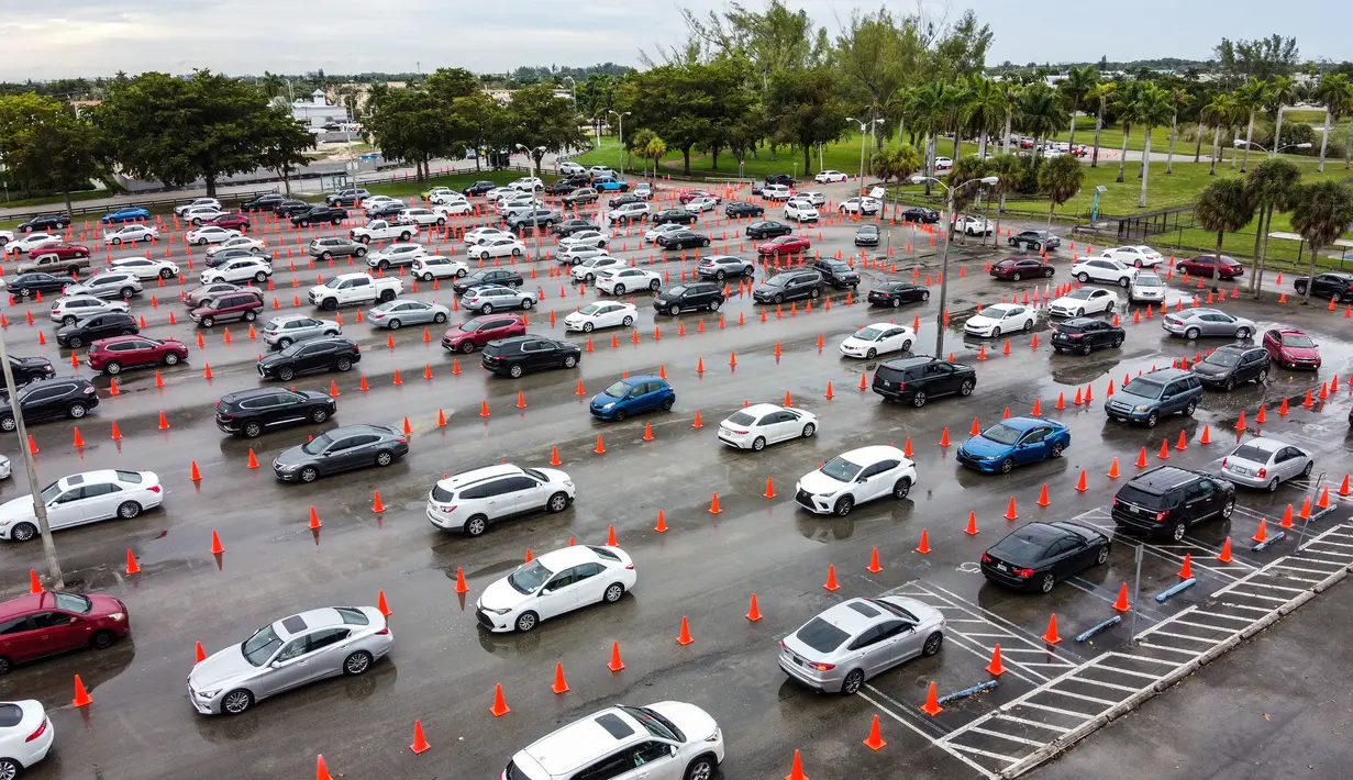Pandangan udara menunjukkan mobil berbaris di lokasi pengujian Covid-19 di Tropical Park di Miami, Florida, Selasa (21/12/2021). Beberapa hari sebelum Natal, orang Amerika menghadapi antrean panjang untuk dites covid-19 di tengah lonjakan baru yang didorong oleh varian Omicron. (CHANDAN KHANNA/AFP)