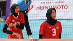 Pemain Timnas Bola Voli Putri Indonesia, Agustin Wulandhari (kiri) dan Megawati Hangestri Pertiwi bersiap saat laga Grup A Bola Voli Putri SEA Games 2023 melawan Timnas Bola Voli Putri Thailand di Olympic Complex Indoor Main Hall, Phnom Penh, Kamboja, Selasa (09/05/2023). (Bola.com/Abdul Aziz)