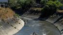 Sejumlah pria mencari logam berharga di Sungai Guaire, di Caracas, Venezuela (1/2). Puluhan warga mencari logam atau tembaga setiap hari di Sungai Guaire, tempat selokan Caracas mengalir.  (AFP Photo/Federico Parra)