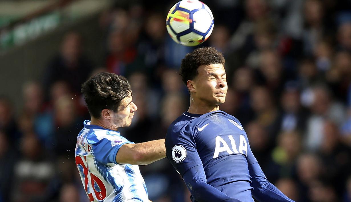 Gelandang Tottenham Hotspur, Dele Alli, duel udara dengan bek Huddersfield Town, Christopher Schindler, pada laga Premier League di Stadion The John Smith, Sabtu (30/9/2017). Tottenham Hotspur menang 4-0 atas Huddersfield Town. (AP/Nigel French)