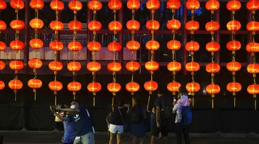 Orang-orang foto di depan dekorasi selama Festival Pertengahan Musim Gugur di taman Victoria di Hong Kong, Selasa (21/9/2021).  Festival ini jatuh pada hari ke-15 bulan ke-8 penanggalan Imlek. (AP Photo/Vincent Yu)