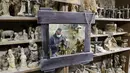 Refleksi cermin memperlihatkan seorang tukang kayu Palestina membuat patung keagamaan dari kayu zaitun di sebuah toko dekat Church of the Nativity, Betlehem, Tepi Barat, 21 Desember 2020. Patung-patung tersebut akan dijual selama musim Natal.(HAZEM BADER/AFP)