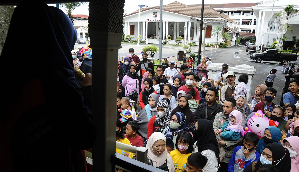Warga antre masuk bus wisata Uncal di depan Balai Kota Bogor, Bogor, Jawa Barat, Minggu (29/5/2022). Bus wisata gratis yang disediakan untuk mengelilingi kawasan Kebun Raya Bogor setiap hari Sabtu dan Minggu ini mulai beroperasi kembali pascapandemi. (merdeka.com/Arie Basuki)