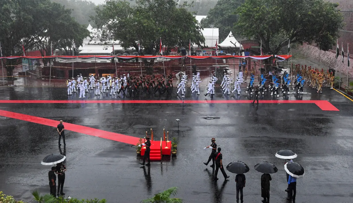Petugas keamanan dan pejabat melakukan gladi bersih upacara Hari Kemerdekaan di monumen Benteng Merah saat hujan di New Delhi, India, Kamis, (13/8/2020). India akan merayakan Hari Kemerdekaan ke-74 pada 15 Agustus. (AFP Photo/Prakash Singh)