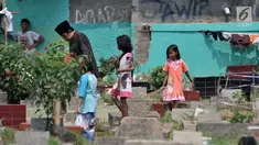 Sejumlah anak mengikuti peziarah saat menawarkan jasa membersihkan makam atau 'Ngoret' di TPU Cipinang Baru, Jakarta, Minggu (5/5). Tradisi ziarah makam atau nyekar membawa berkah rezeki bagi anak-anak yang menawarkan jasa Ngoret. (merdeka.com/Iqbal S. Nugroho)