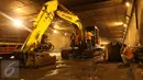 Pekerja menggunakan alat berat untuk memperbaiki jalan yang rusak berlubang di ruas Tol JORR tepatnya di terowongan Pasar Rebo, Jakarta, Senin (29/2) malam. Kondisi jalan yang rusak itu menyebabkan kemacetan panjang. (Liputan6.com/Herman Zakharia)