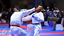 Karateka Jawa Timur, Umar Syarief (kiri) menyarangkan pukulan ke arah Caesar George (Jakarta) di kelas Kumite Individu Putra +84 kg senior PON XIX di Sabuga, Bandung, Minggu (18/9). Umar menang telak 9-1 atas Caesar. (Liputan6.com/Helmi Fithriansyah)