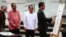 Presiden Jokowi menggores kuas di kanvas putih sebagai tanda dibukanya pameran seni rupa koleksi Istana Kepresidenan RI bertajuk ‘17:71 Goresan Perjuangan’ di Galeri Nasional, Jakarta, Senin (1/8). (Liputan6.com/Faizal Fanani)