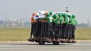 Anggota Tornado dari Army Service Corps (ASC) berada di satu motor 500 cc di Bangalore, India (19/11). Tim Tornado menciptakan rekor dunia baru setelah 58 orang naik satu motor 500 cc dan mengendarainya sejauh 1200 meter. (AFP Photo/Manjunath Kiran)
