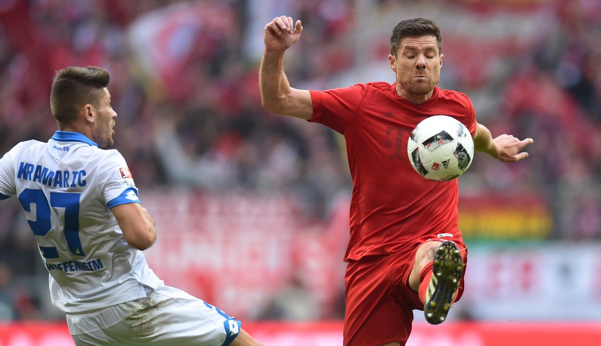 Pemain Hoffenheim, Andrej Kramaric (kiri) berusaha menjangkau bola dari kejaran  pemain Bayern Munich, Xabi Alonso (kanan) pada laga Bundesliga di Stadion Alianz Arena, Munich, (5/11/2016). (AFP/Christof Stache)