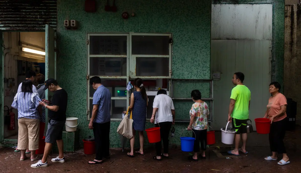 Sejumlah pusat bisnis dan pendidikan serta beberapa stasiun kereta bawah tanah terendam banjir. Warga mengantre untuk mengambil air setelah pipa meledak setelah tanah longsor dan hujan badai di Hong Kong, Jumat, 8 September 2023. (AP Photo/Louise Delmotte)