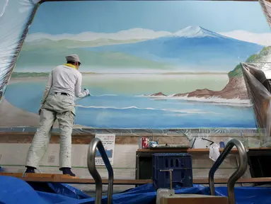  Mizuki Tanaka saat sibuk melukis pemandangan Gunung Fuji di tembok suatu pemandian air panas atau sento  di pusat kota Tokyo,Jepang,  Jumat (2/10/2015). Hanya ada tiga orang di Jepang yang masih berprofesi sebagai pelukis sento. (REUTERS/Issei Kato)