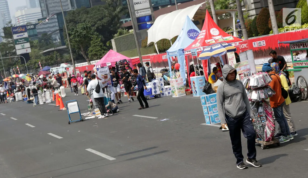 Pedagang kaki lima (PKL) menggelar dagangannya di Jalan Jenderal Sudirman saat Hari Bebas Kendaraan, Jakarta, Minggu (25/8/2019). Para PKL ini menggelar dagangannya terlalu menjorok ke tengah jalan sehingga mengganggu kenyamanan warga yang berolahraga saat CFD. (Liputan6.com/Helmi Fithriansyah)