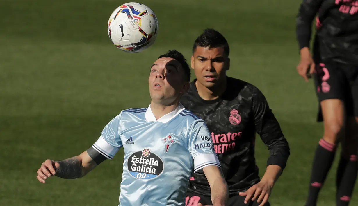 Striker Celta Vigo, Iago Aspas (kiri) mengontrol bola di depan gelandang Real Madrid, Casemiro dalam laga lanjutan Liga Spanyol 2020/2021 pekan ke-28 di Balaidos Stadium, Sabtu (20/3/2021). Celta Vigo kalah 1-3 dari Real Madrid. (AP/Lalo R. Villar)