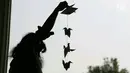 Warga memasang burung origami di halaman Balai Kota, Jakarta, Sabtu (27/5). Seribu Origami Burung Perdamaian imi merupakan aksi atau gerakan spontanitas atas dasar kecintaan kepada Negara Kesatuan Republik Indonesia (NKRI). (Liputan6.com/Angga Yuniar)