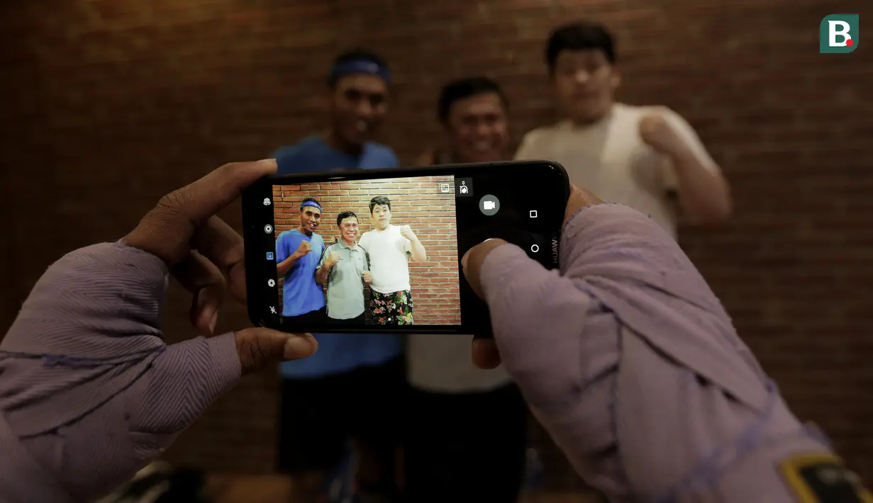 Legenda tinju Indonesia, Ellyas Pical, foto bersama petinju muda di Kawasan Bintaro, Jumat (13/7/2018). Ellyas Pical adalah petinju Indonesia pertama yang berhasil menjadi juara dunia. (Bola.com/M Iqbal Ichsan)
