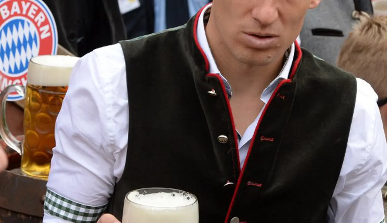 Arjen Robben menenteng segelas bir saat memperingati Oktoberfest, Jerman, Minggu (5/10/2014) (AFP PHOTO/CHRISTOF STACHE)