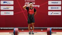 Lifter andalan Indonesia, Eko Yuli Irawan, yang beraksi di cabang angkat besi putra 62 kg, merebut medali emas Asian Games 2018 di arena JIEXPO, Jakarta, Selasa (21/8/2018). (AFP/Money Sharma)