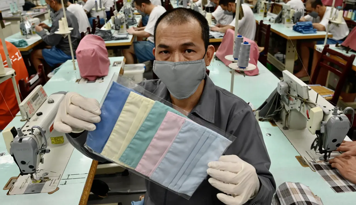 Seorang narapidana menunjukkan masker di ruang kerja menjahit di Penjara Taipei di Kota Taoyuan, Taiwan utara (10/3/2020). Taiwan berhasil mempertahankan jumlah kasus virus corona yang dikonfirmasi menjadi 45 dan satu kematian. (AFP/Sam Yeh)